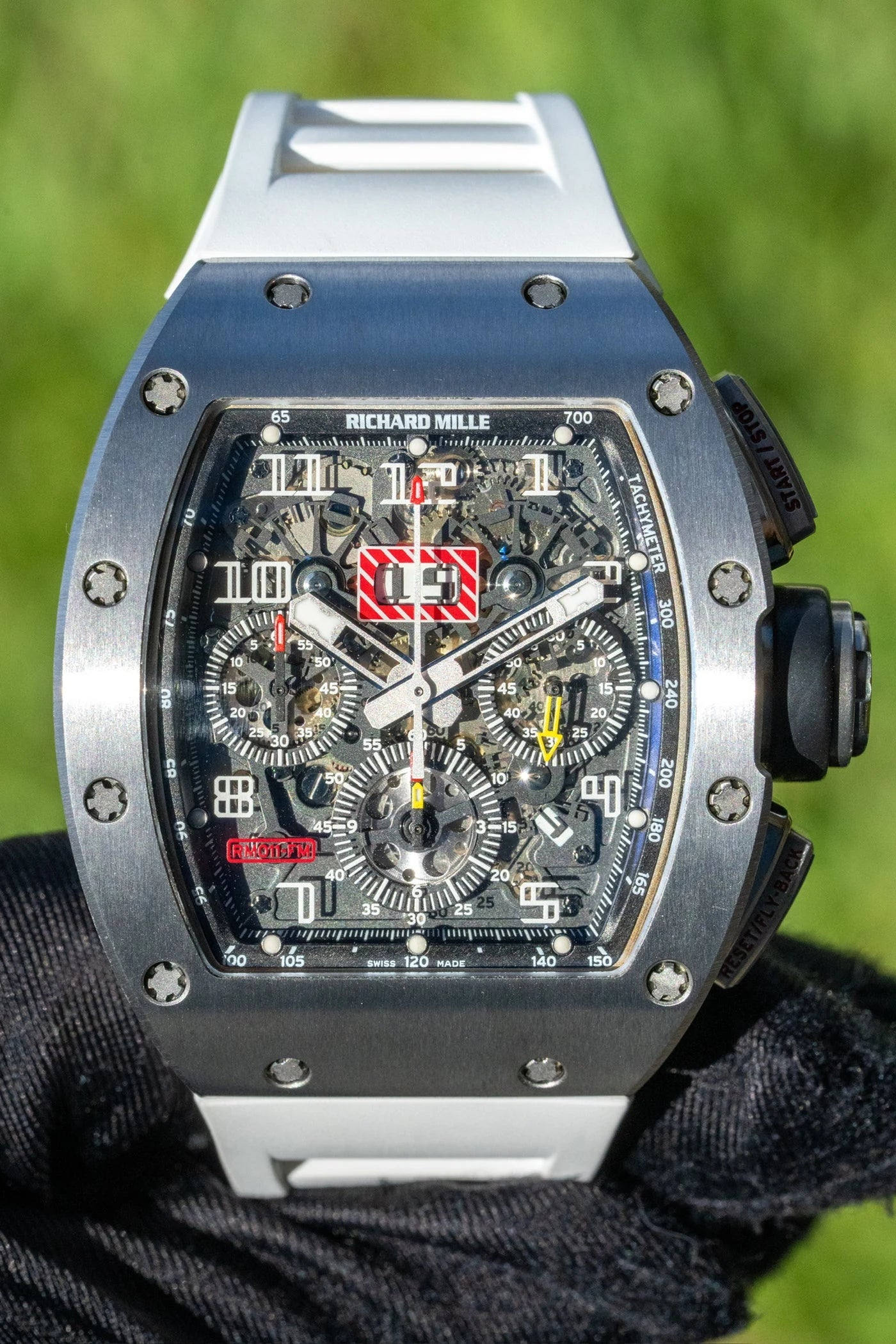 Close view of a Richard Mille watch with a skeleton dial and red date display