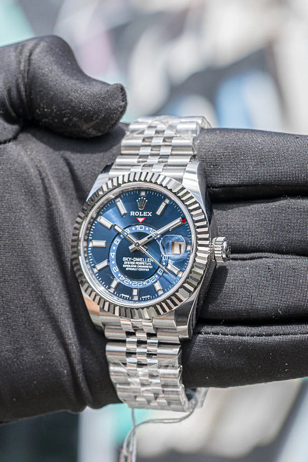 Blue dial Rolex Sky Dweller held in a black glove