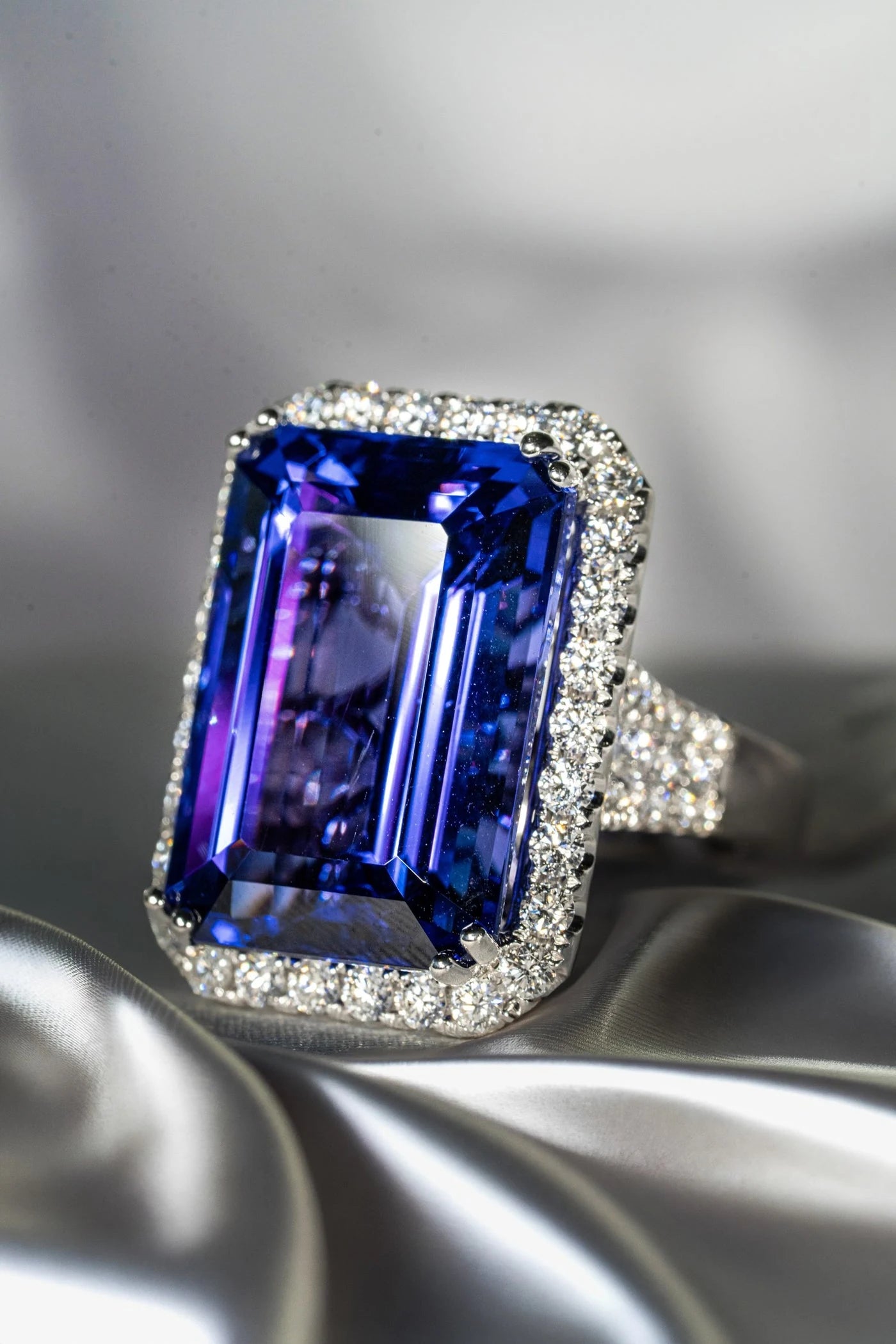 Rectangular violet-blue center stone ring on pale fabric