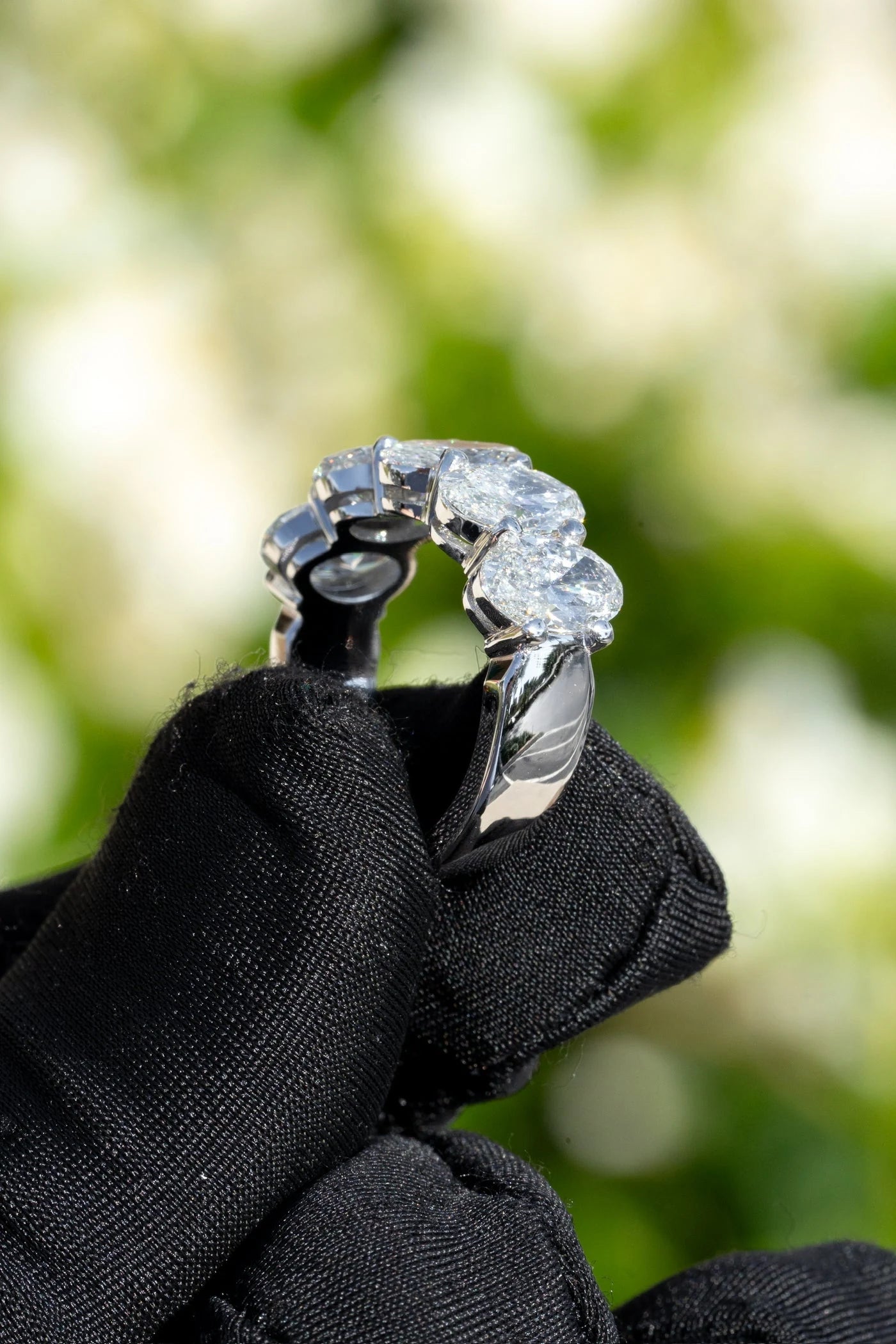 Stone set band held in a black glove