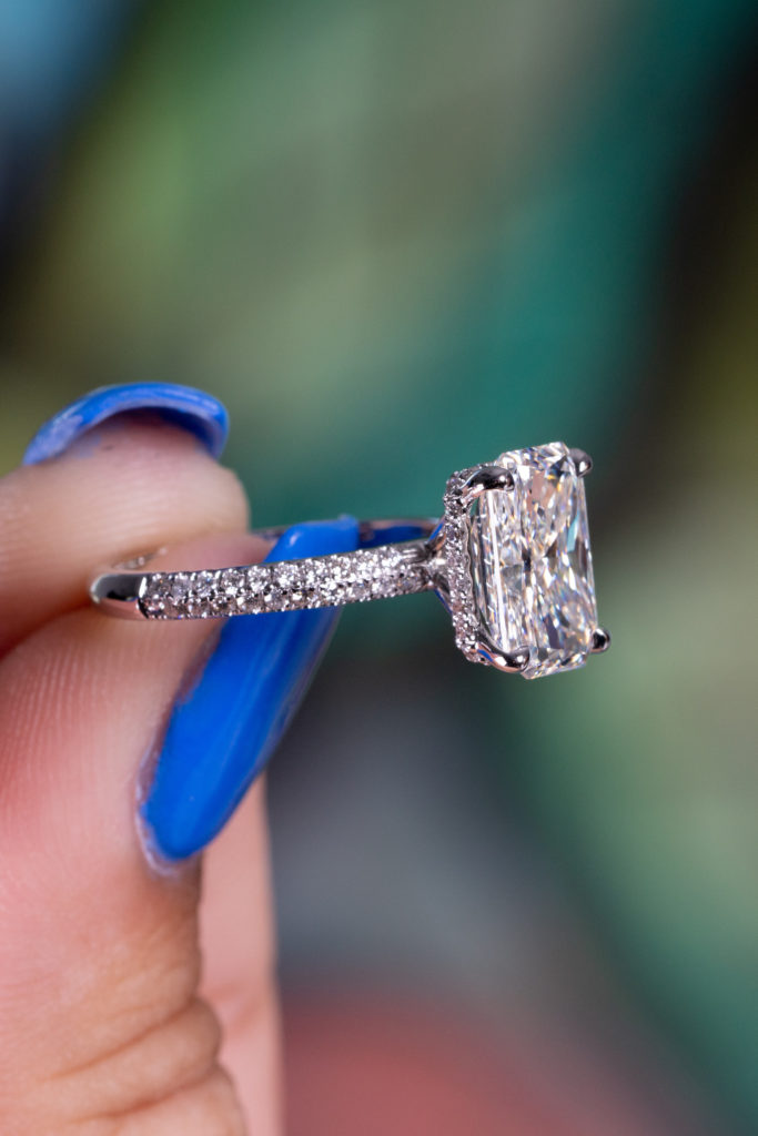 close view of a white cushion diamond ring with accents